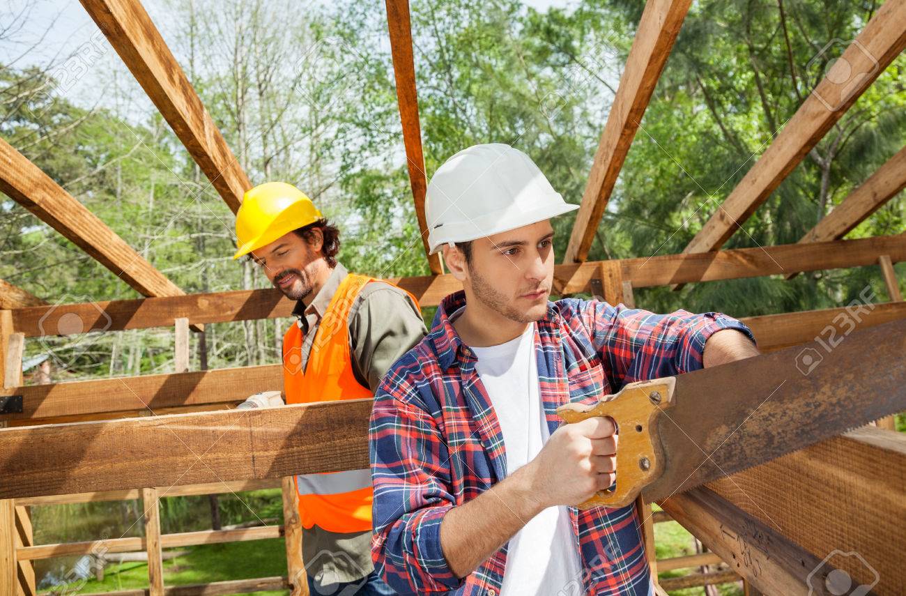 trabajador de construcción de cortar madera con serrucho